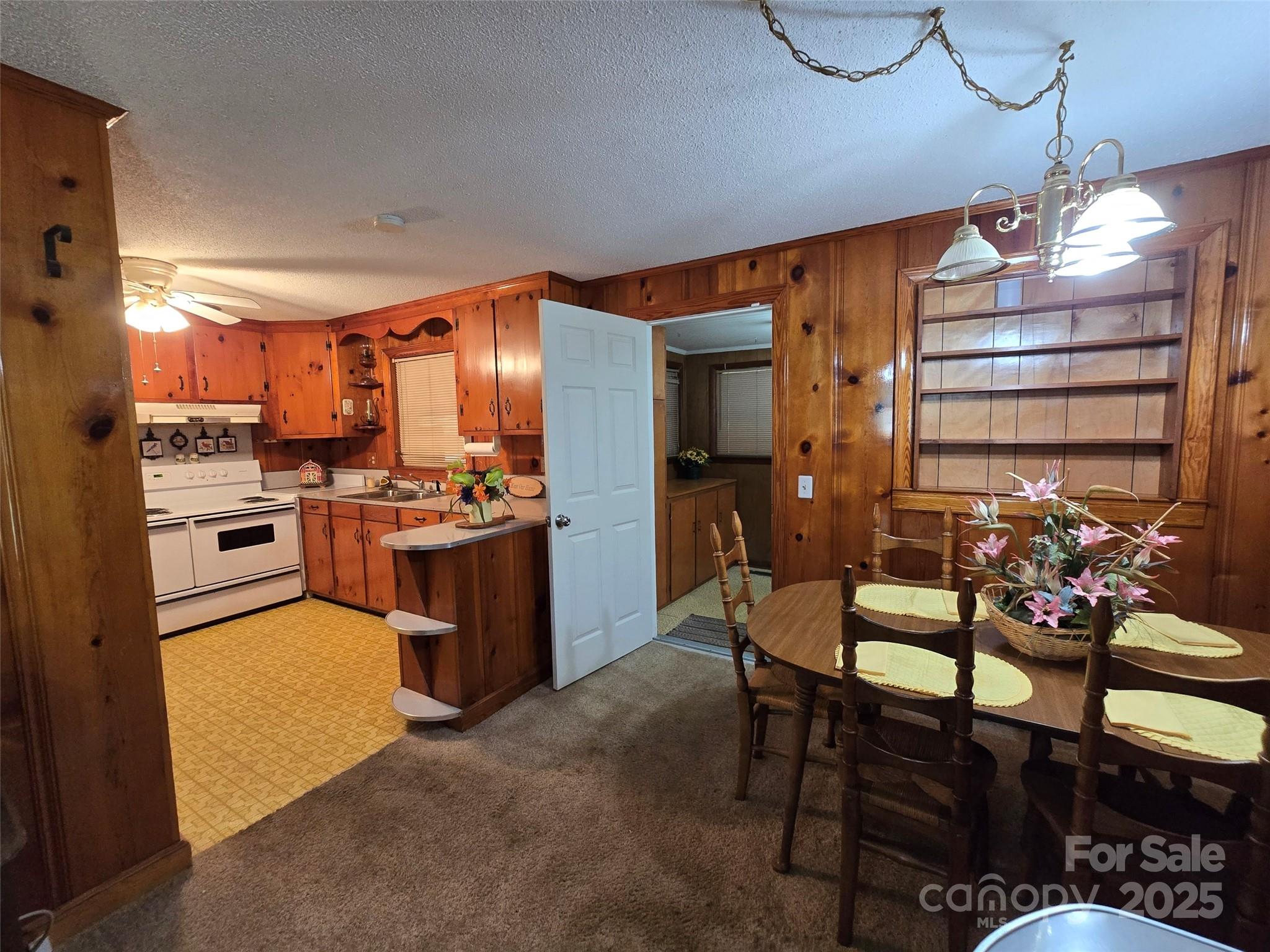 517 Mask Road Mount Gilead, NC 27306 - Photo 22 of 48 a kitchen with a refrigerator a stove top oven a sink dishwasher and dining table with wooden floor