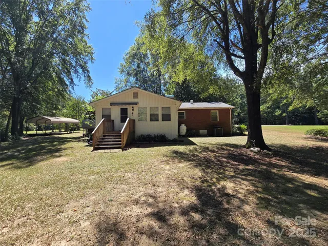 a front view of a house with a yard and trees