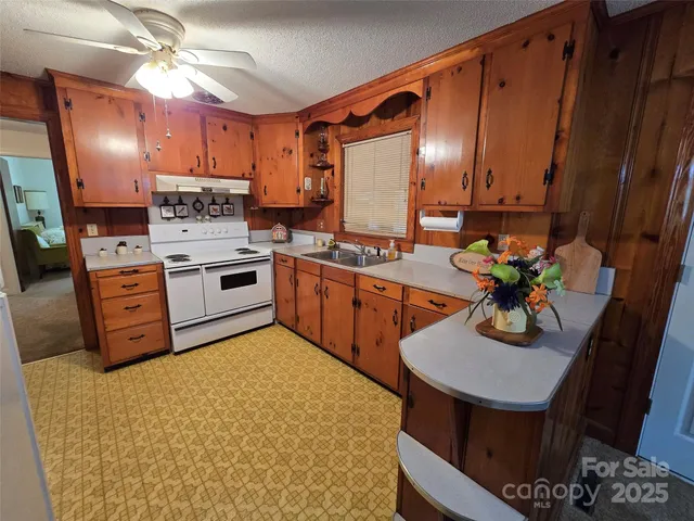 a kitchen with stainless steel appliances granite countertop a sink dishwasher stove and refrigerator