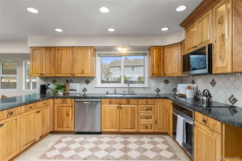 a large kitchen with stainless steel appliances granite countertop a sink and cabinets
