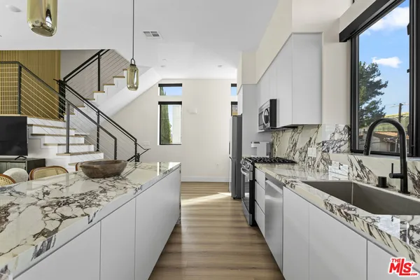 a kitchen with stainless steel appliances granite countertop a sink and a stove