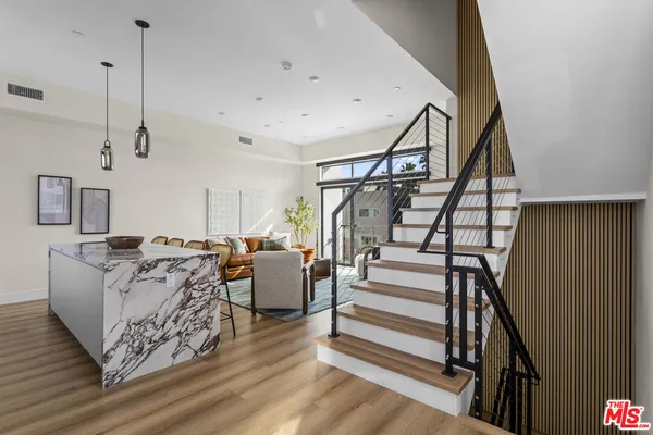 a living room with furniture a flat screen tv and a floor to ceiling window