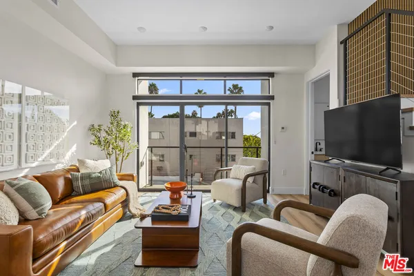 a living room with furniture tv and wooden floor