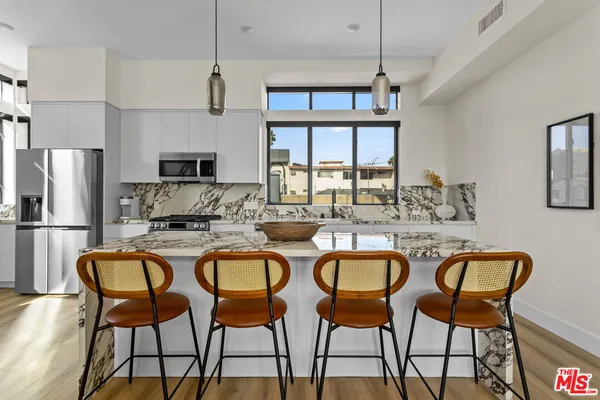 a view of a dining room and livingroom with furniture wooden floor a chandelier
