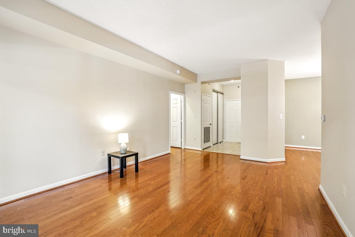 14809 Pennfield Circle, Unit 105 Silver Spring, MD 20906 - Photo 13 of 29 a view of an empty room with wooden floor and a window