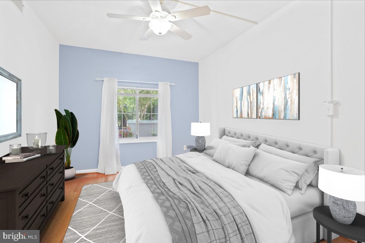 14809 Pennfield Circle, Unit 105 Silver Spring, MD 20906 - Photo 17 of 29 a bedroom with a bed a computer on the desk and a window