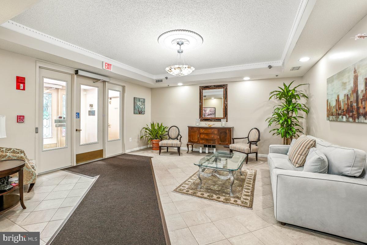 14809 Pennfield Circle, Unit 105 Silver Spring, MD 20906 - Photo 27 of 29 a living room with furniture and a chandelier