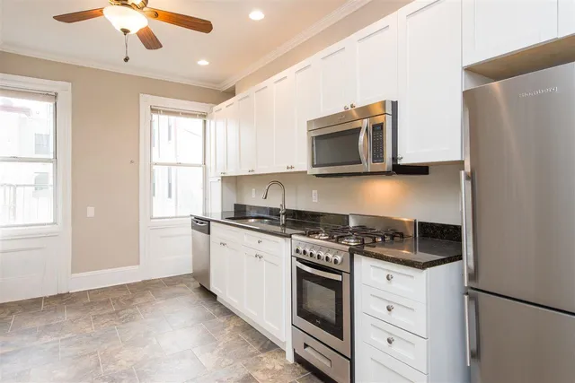 a kitchen with stainless steel appliances granite countertop a stove and a microwave