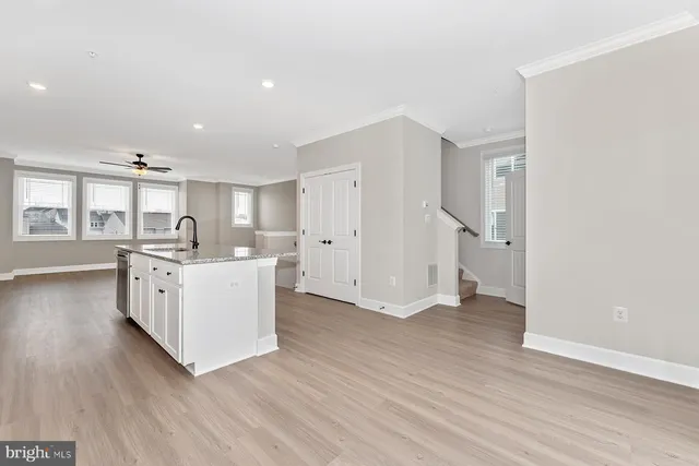 a kitchen with white cabinets and window