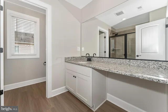 a bathroom with a granite countertop sink and a mirror