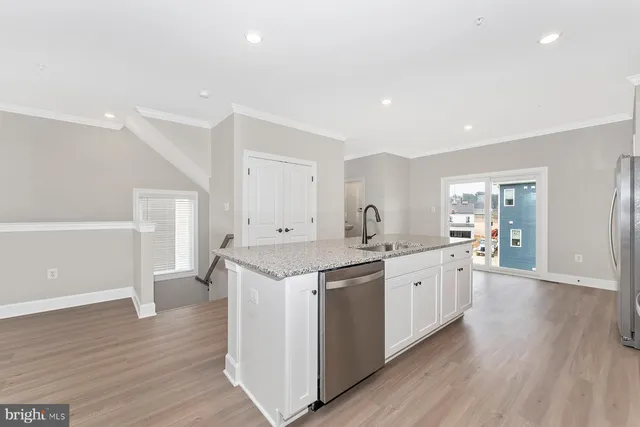 a kitchen with granite countertop a sink and wooden floor