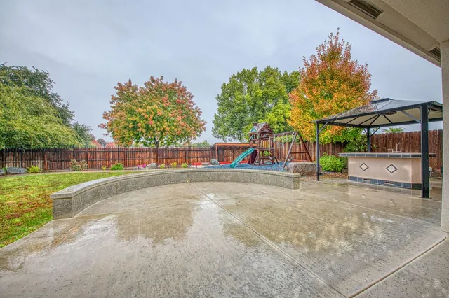 a view of kitchen with granite countertop cabinets and refrigerator
