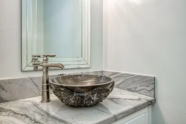 a bathroom with a granite countertop double vanity sink and a large mirror