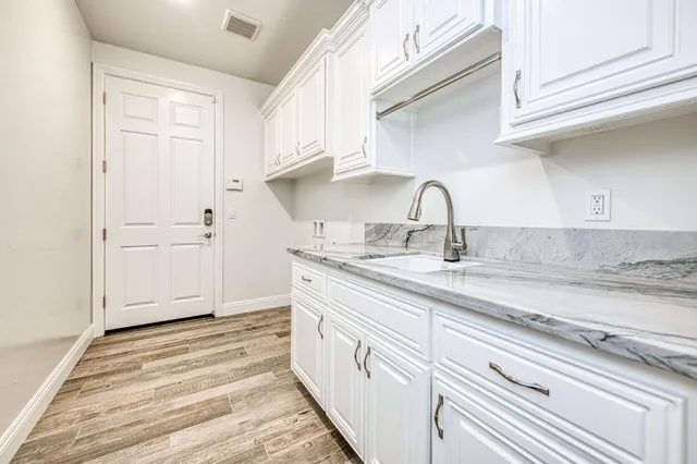 a kitchen with center island white cabinets and stainless steel appliances