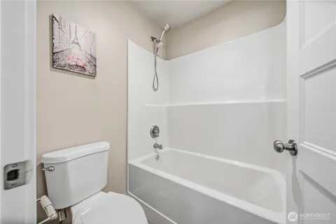 a white toilet sitting next to a bath tub