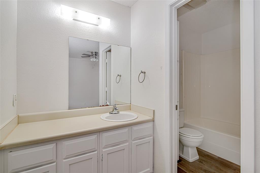 1312 Ridge Run Street, Unit A Cleburne, TX 76033 - Photo 11 of 16 a bathroom with a sink a toilet and shower