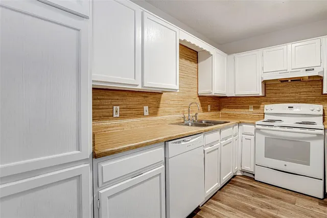 a kitchen with granite countertop cabinets stainless steel appliances and a sink