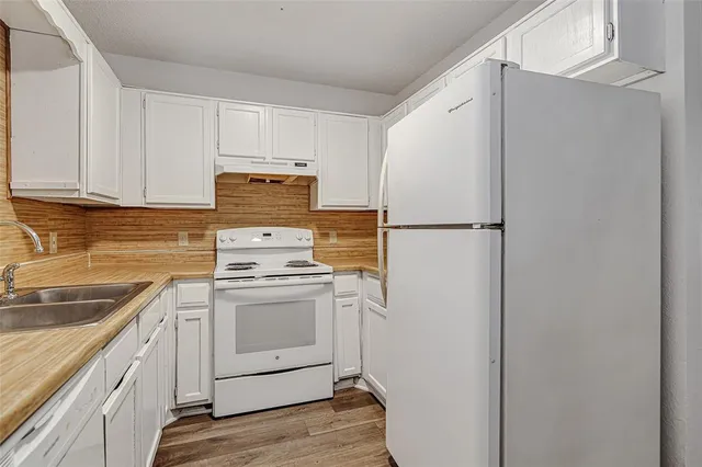 a kitchen with a refrigerator sink and cabinets