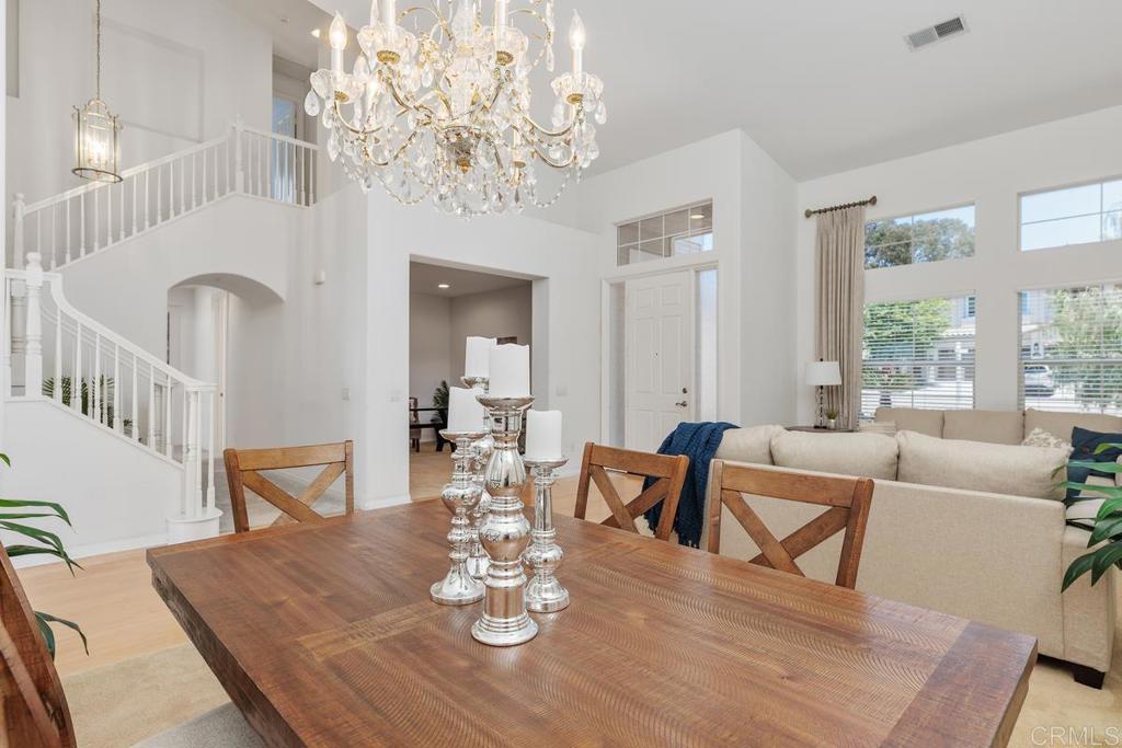 250 Pacific View Lane Encinitas, CA 92024 - Photo 11 of 40 a view of a dining room with furniture a chandelier and wooden floor