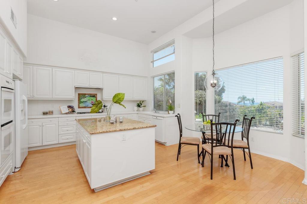 250 Pacific View Lane Encinitas, CA 92024 - Photo 16 of 40 a kitchen with a table chairs sink and cabinets