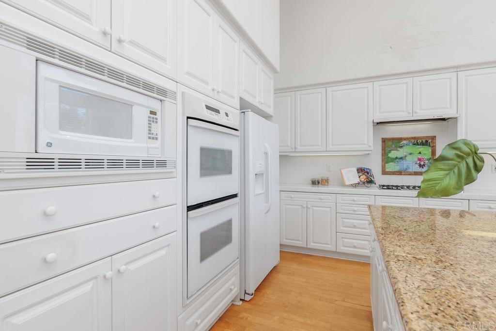 250 Pacific View Lane Encinitas, CA 92024 - Photo 18 of 40 a kitchen with granite countertop white cabinets and white appliances