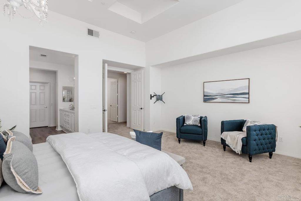 250 Pacific View Lane Encinitas, CA 92024 - Photo 22 of 40 a bedroom with bed a couch and a dresser with a large mirror