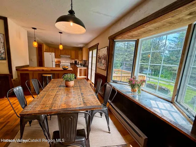 a dining room with furniture a chandelier and wooden floor