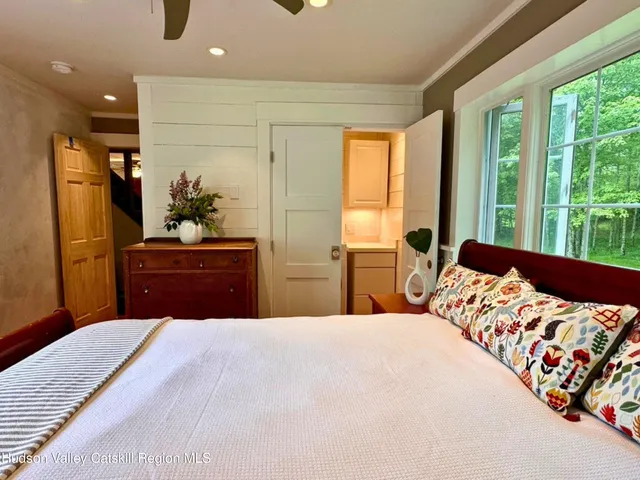 a bedroom with a bed and large windows