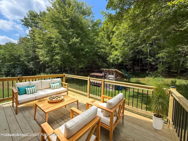 a balcony with wooden floor and outdoor seating