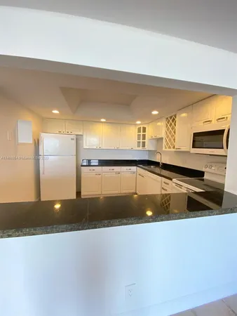 a large kitchen with stainless steel appliances a large counter top