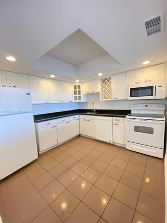 a large white kitchen with a sink and cabinets