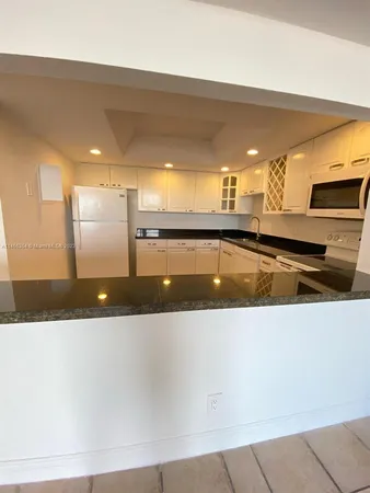 a large kitchen with stainless steel appliances a large counter top