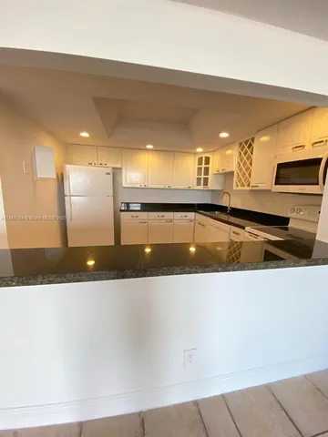 a large kitchen with stainless steel appliances a large counter top