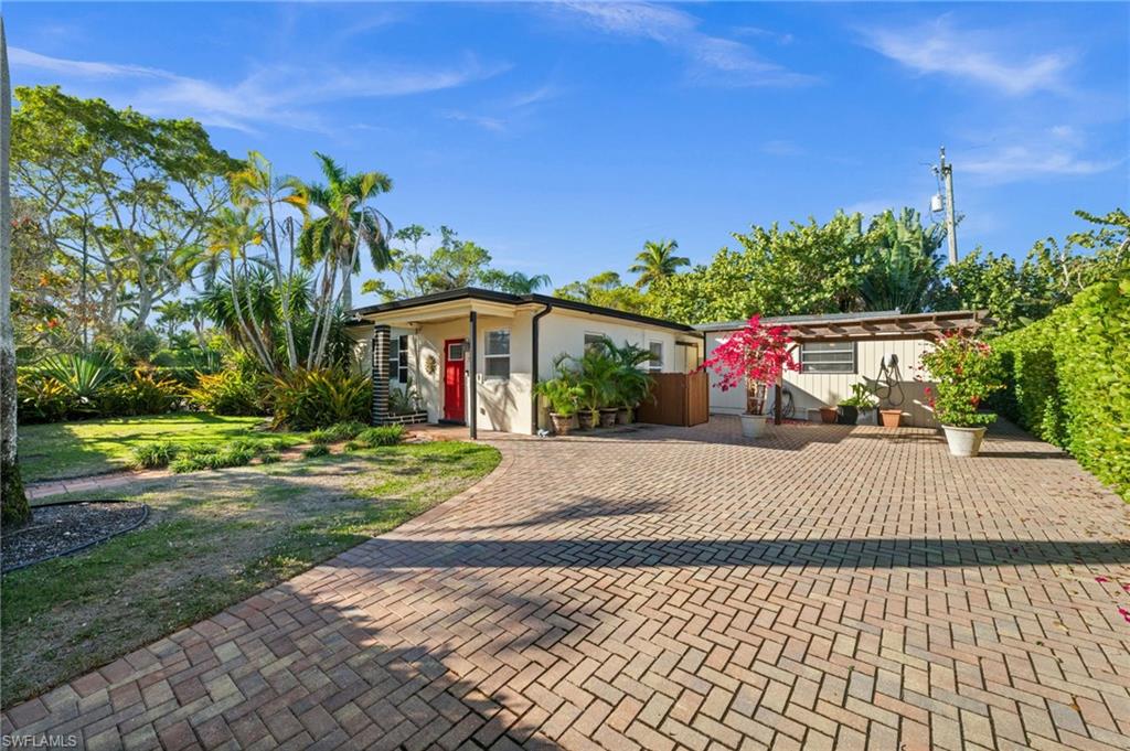 715 10th Street North Naples, FL 34102 - Photo 2 of 36 a view of a white house with a yard