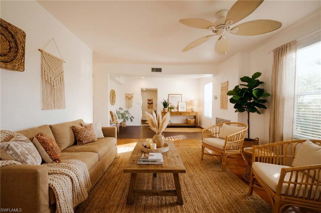 715 10th Street North Naples, FL 34102 - Photo 4 of 36 a living room with furniture a potted plant and a large window