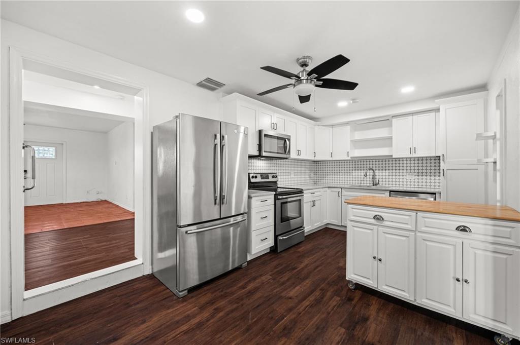 715 10th Street North Naples, FL 34102 - Photo 7 of 36 a kitchen with stainless steel appliances a refrigerator sink and cabinets
