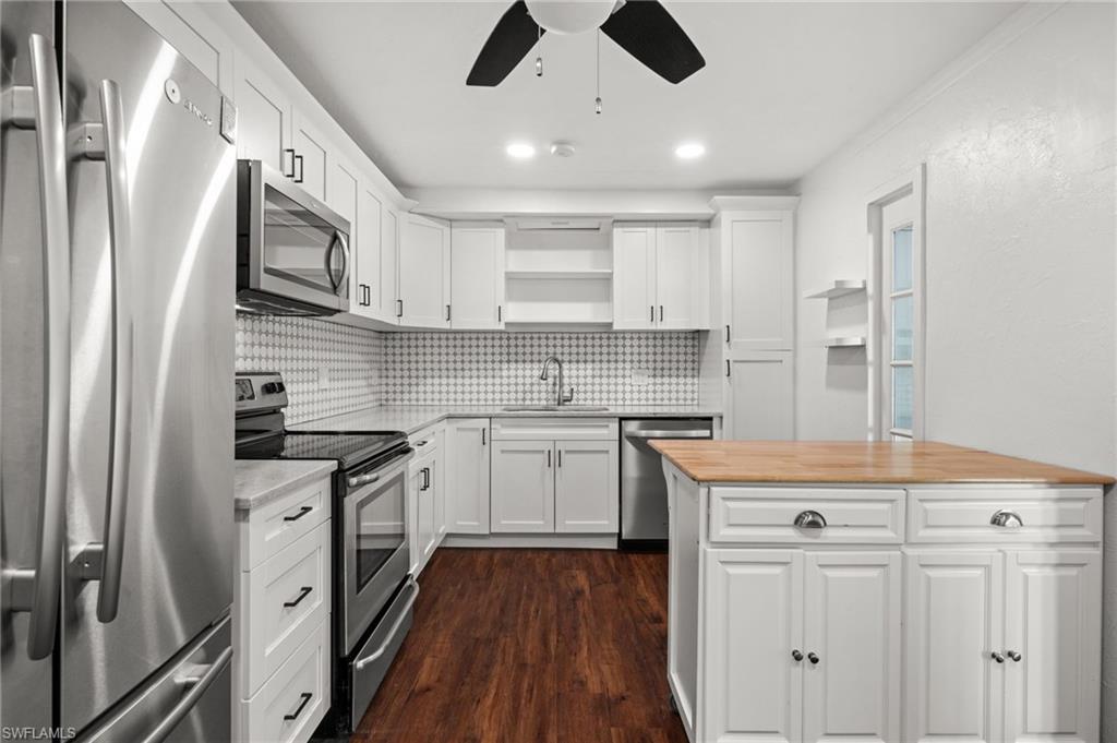 715 10th Street North Naples, FL 34102 - Photo 8 of 36 a kitchen with stainless steel appliances granite countertop a sink stove and refrigerator