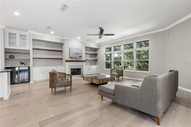 a living room with furniture fireplace and a large window