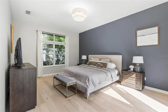a bedroom with a bed flat screen tv and window