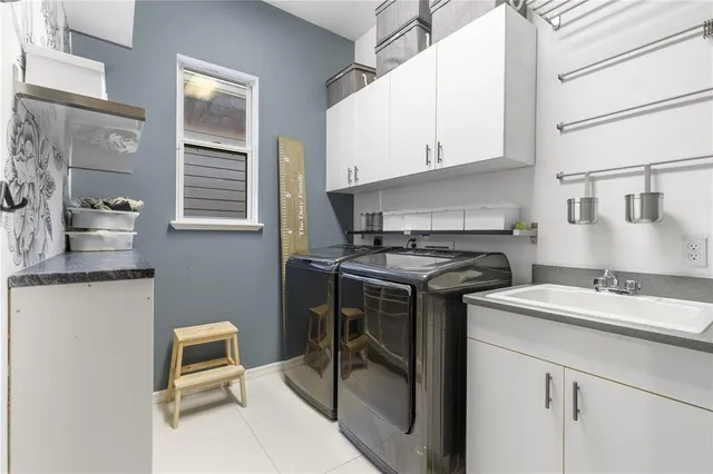 a kitchen with a stove a sink and white cabinets