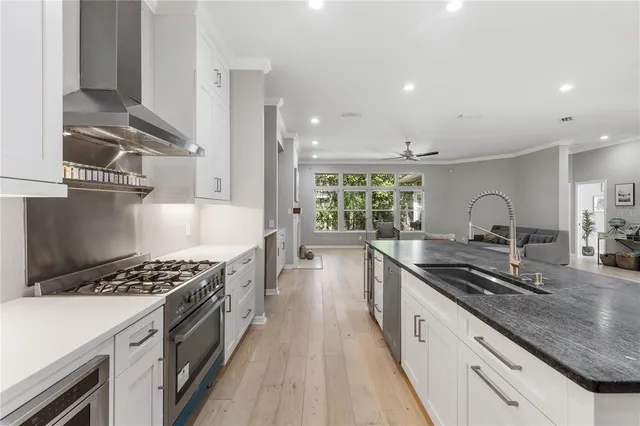 a kitchen with granite countertop a sink stove and cabinets