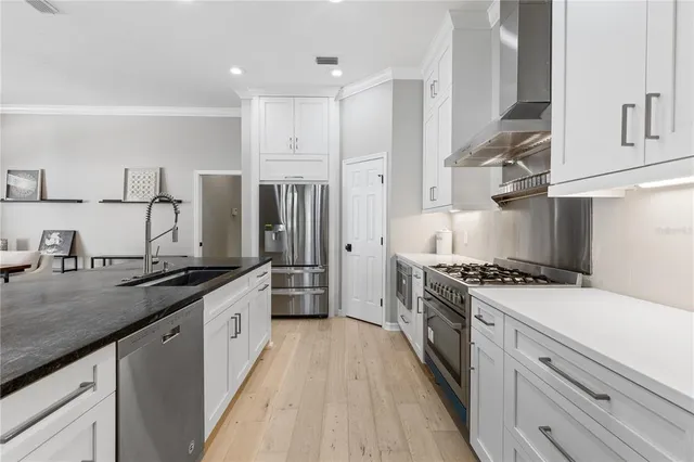 a large kitchen with stainless steel appliances granite countertop a lot of counter space and wooden floors