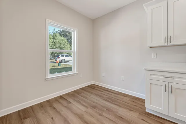 a view of a livingroom with wooden floor and a ceiling fan