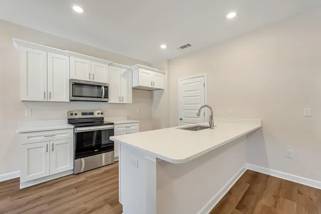 a kitchen with sink a microwave and cabinets