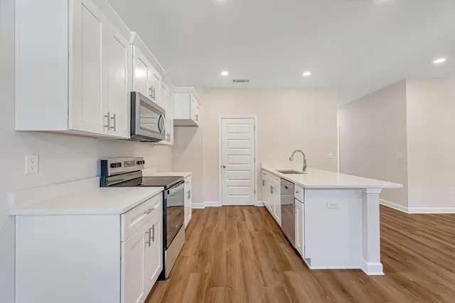 a kitchen with cabinets a sink and wooden floor