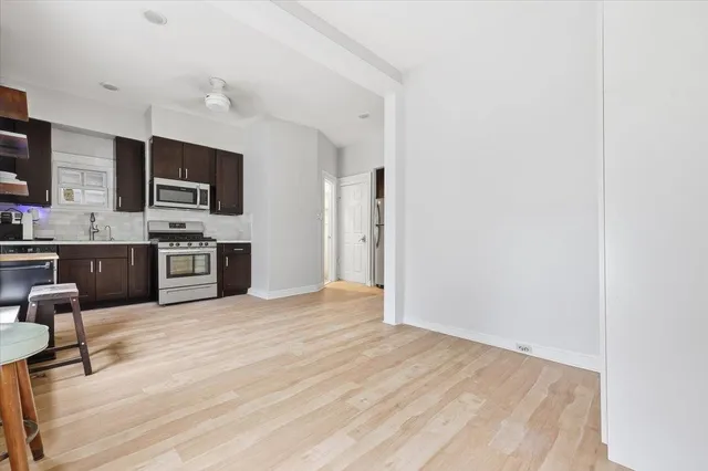 a view of kitchen with wooden floor and electronic appliances