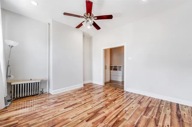 a view of a room with wooden floor and ceiling fan