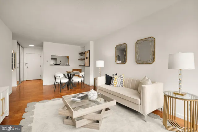 a living room with furniture a wooden floor and next to a window