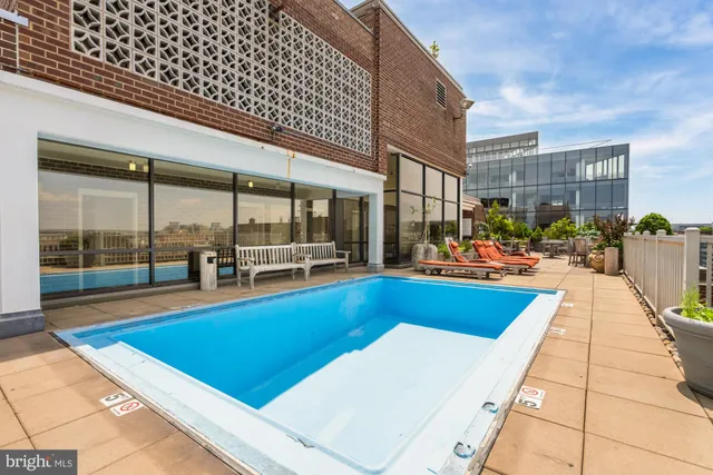 a roof deck with outdoor seating and city view