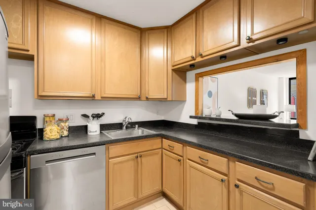 a kitchen with stainless steel appliances granite countertop a sink a stove and refrigerator